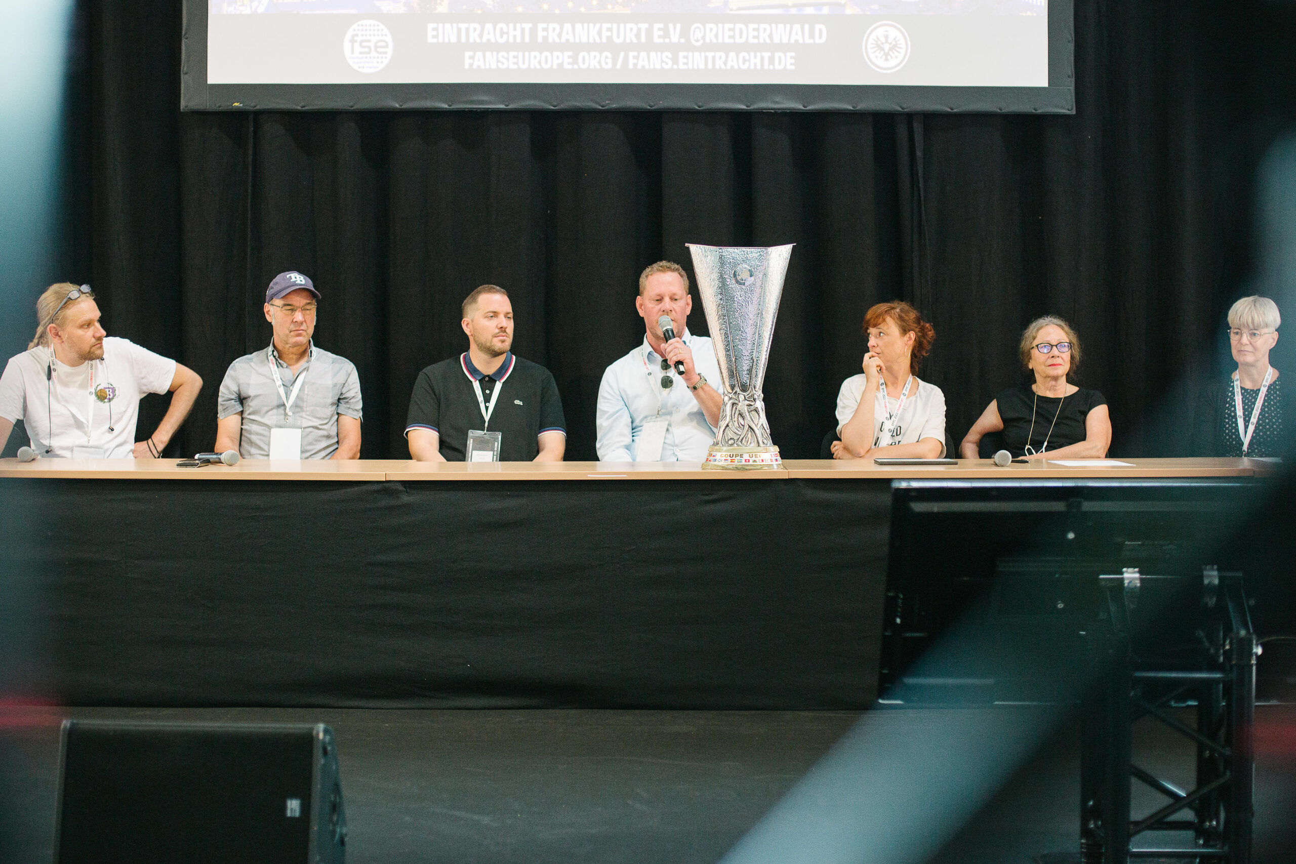 A panel of experts discuss German fandom at EFFC22. The Europa League trophy is on the table in front of them.
