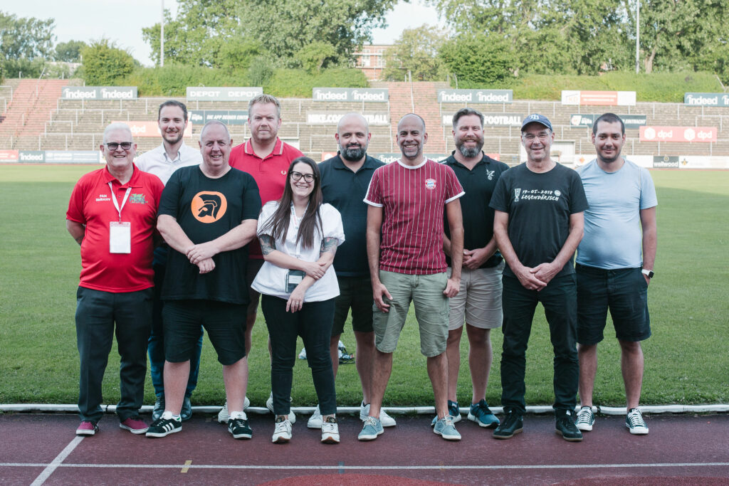 The FSE Board stands on a running track in front of a football field at the Riederwaldstadion. 