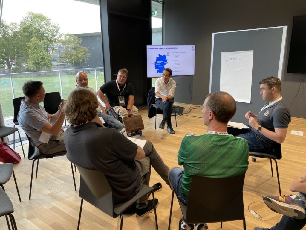 Participants in a workshop sit in a circle and discuss EURO 2024.