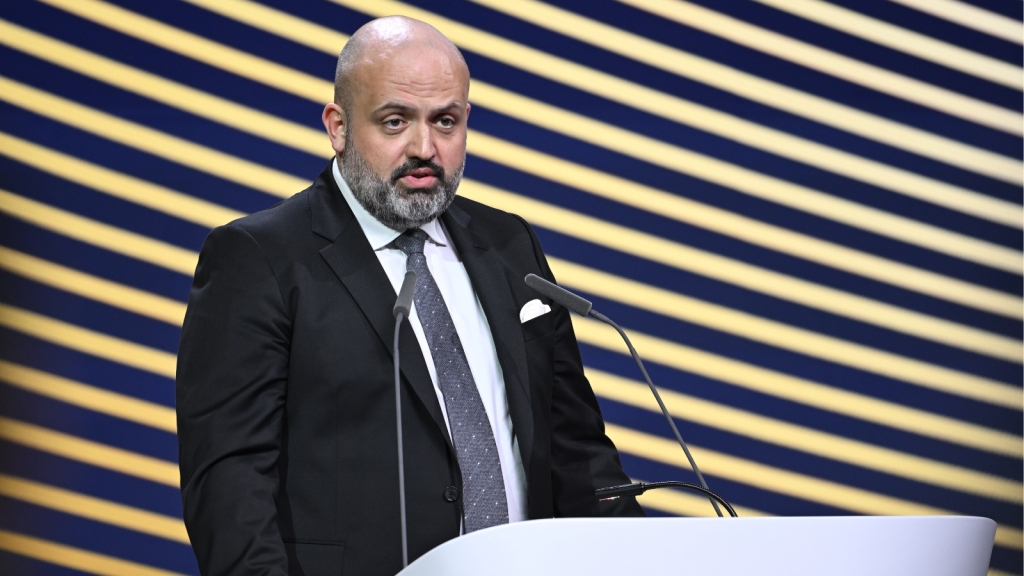 FSE Executive Director Ronan Evain stands behind a lecturn delivering a speech on a stage. 